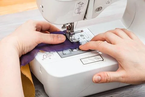 Designer stitches bands of fabrics for patchwork workshop on sewing a patc... Stock Photos