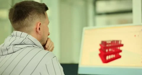 Designer studies 3D model of parts on computer monitor in office Stock Footage 250164516