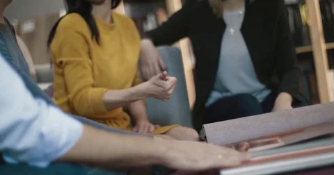 The designer at studio shows her clients wallpaper samples Stock Footage 83079603