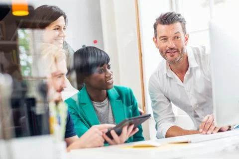 Designer team looking at computer in creative studio 스톡 사진