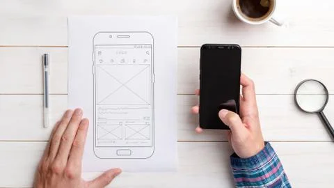 Designer tests the user interface and user experience on a mobile phone. Wire Stock Photos