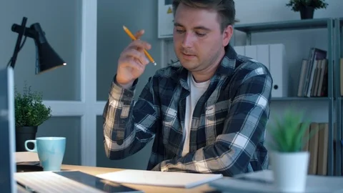Designer is thinking about solving his project while sitting in the office. The  Stock Footage 114744763