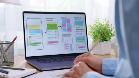 A designer uses a pen to point at mobile application user interface wireframes Stock Footage 341940238