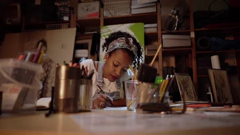 Designer using a pencil and a sheet of paper to make fashion sketches. Africa Stock Footage 152344931