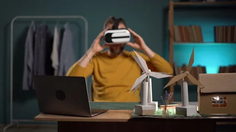 Designer using VR glasses visualizing renewable energy project sitting at home Stock Footage 247457035