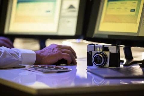 Designer Working On Computer With Camera On Desk Foto stock