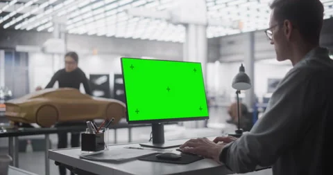 Designer Working on Computer with Green Screen in Car Studio Stock Footage 243272889