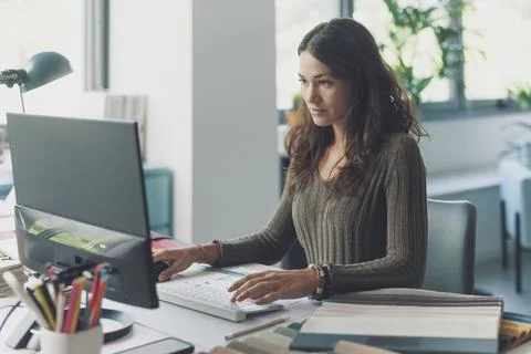 Designer working with her computer in her studio Stock Photos