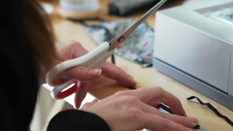 Designer working at home creates face masks as protection against  viruses Stock Footage 127652441
