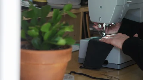 Designer working at home creates face masks as protection against  viruses Stock Footage 127655316