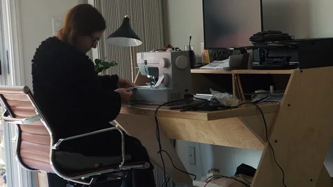 Designer working at home creates face masks as protection against  viruses Stock Footage 127657603