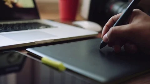 Designer working on a laptop with a graphics tablet. Видео 76781177