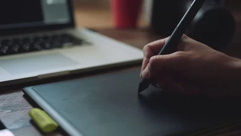 Designer working on a laptop with a graphics tablet. Video stock 76781587