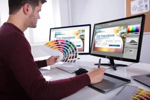 Designer Working On Multiple Computer Screens Foto stock