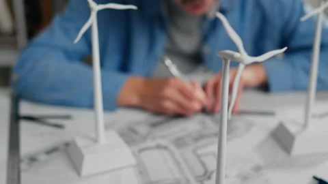 Designer working on a wind turbine model in a creative workspace during dayl Stock Footage 323711128