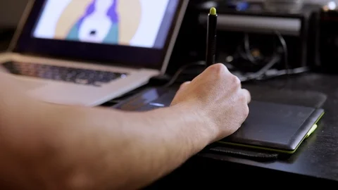 Designer works with graphics tablet and laptop. Medium shot Stock Footage 124878445