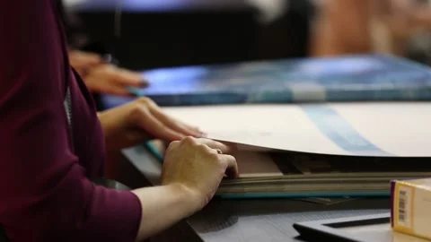 Designers browsing and viewing catalogues with home interiors and materials for Stock Footage 88432733