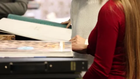 Designers browsing and viewing catalogues with home interiors and materials for Stock Footage 88432811