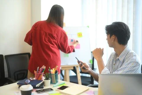Designers discussing user interface ideas while reviewing a smartphone and Foto stock