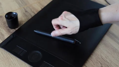 Designer's hand puts on a black drawing glove, picks up a stylus, and draws.. Stock Footage 339018350