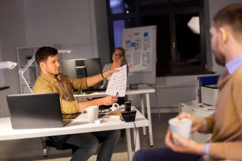 Designers or software developers at night office 스톡 사진