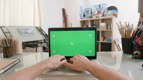 Designers point of view working on a laptop with green screen on Stock Footage 105705722
