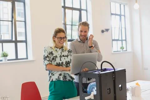 Designers using laptop at 3D printer in office Foto stock
