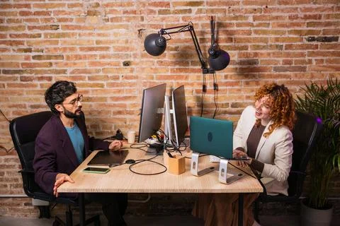 Designers working together at the office using computer and laptop Stock Photos