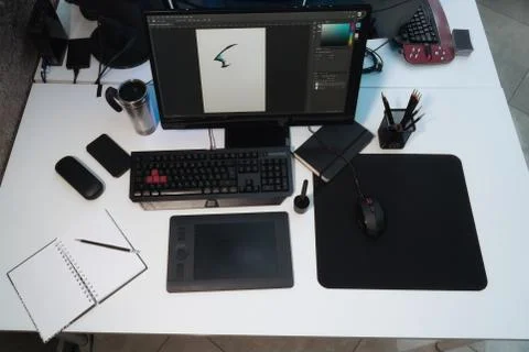 Designer's workplace. A white table on which stands a monitor, a mug, a noteb Stock Photos