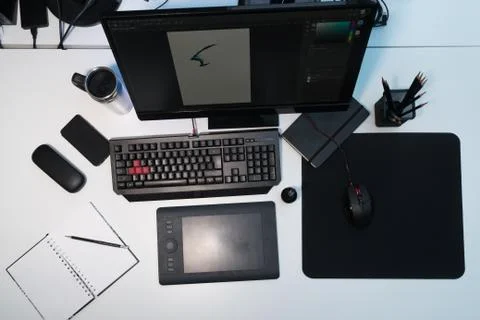 Designer's workplace. A white table on which stands a monitor, a mug, a noteb Stock Photos