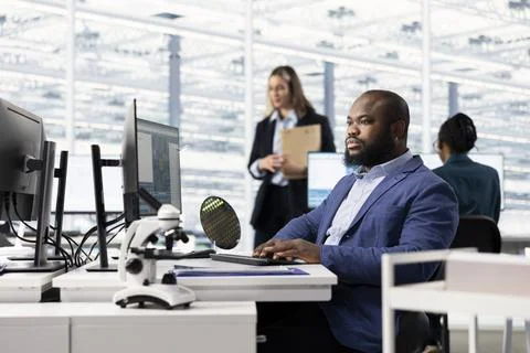 Designing microchip layout, PC and technician in semiconductor research facility Stock Photos