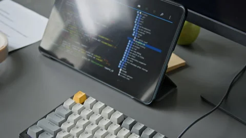 Desk of Algorithm Developer with Notes and Tablet Displaying Computer Code Video stock 335938259