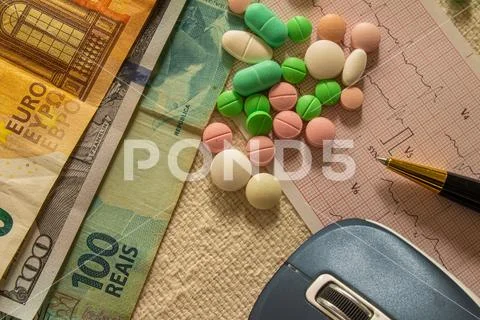Desk with bills and medicines. Concept of cost of health and drug addiction. Stock Photos