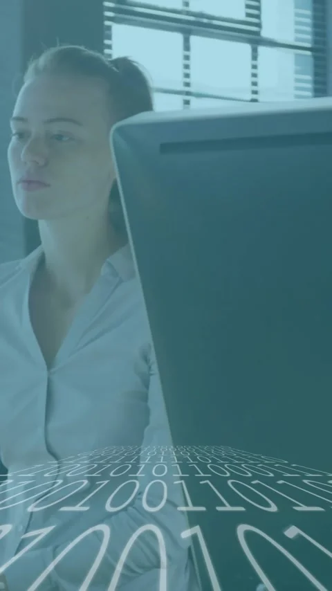 At desk, businesswoman working with binary code animation overlay, focused on 動画素材 344244808