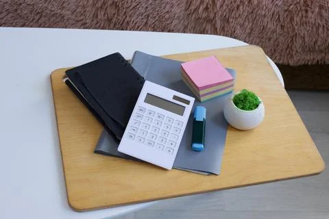 Desk essentials: calculator, notebook, sticky notes, and a small plant Stock Photos