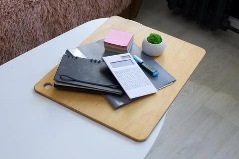 Desk essentials: calculator, notebooks, sticky notes, and a small plant Stock Photos