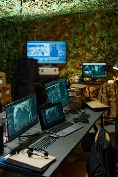 Desk with group of computer monitors with graphic data on screens 写真素材