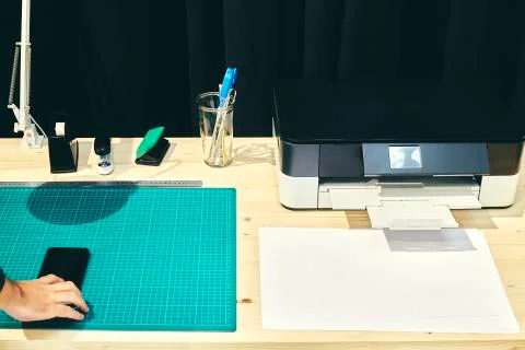 Desk with its printer and a mobile phone Stock Photos