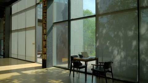 A desk in the library and a tree silhouette reflected in the window Stock Footage 86091083