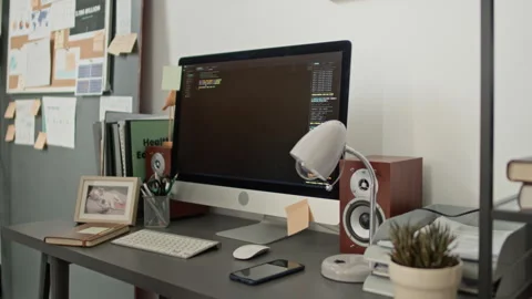 Desk with Monitor Displaying Open-Source Code, Cluttered with Office supplies Stock Footage 333216632