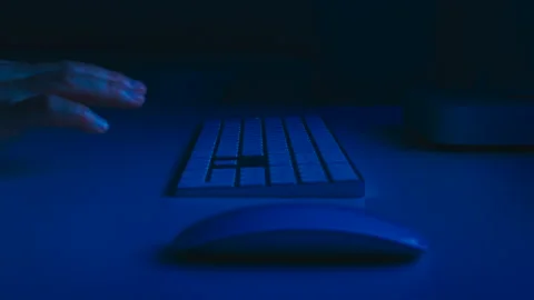 A desk in an office with a mouse and keyboard the user presses Enter. Video stock 328352133