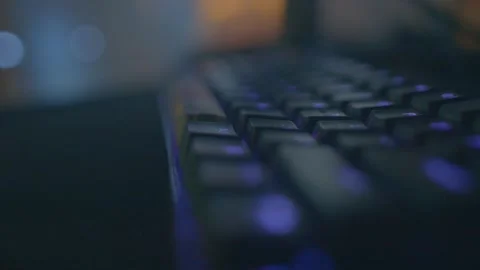 Desk scene featuring illuminated keyboard under soft lighting Видео 334119111