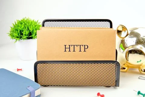 A desk setup features a black mesh organizer holding HTTP labeled folders, a  Stock Photos
