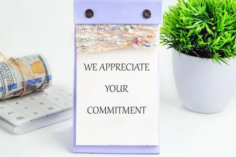 A desk setup features a commitment message alongside a calculator and stacked Foto stock