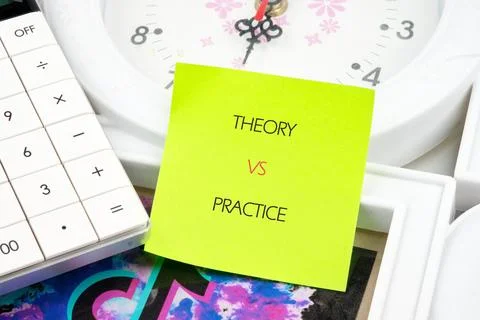 A desk setup includes a calculator and a clock with a colorful sticky note di Stock Photos