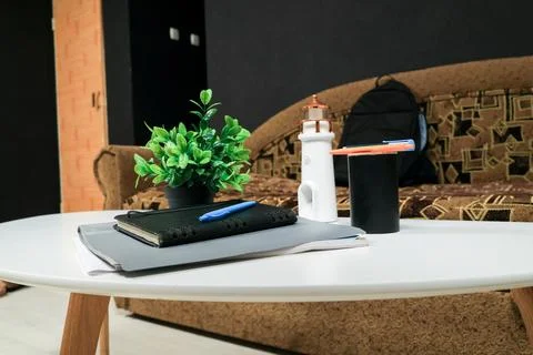 Desk setup with notebook, plant, and lighthouse decor on a white table Stock Photos