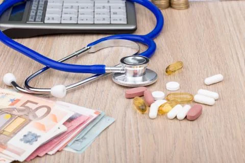 A desk with a stethoscope and objects that relate to health care costs Stock Photos