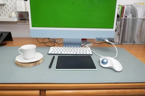 Desk view with a modern computer featuring a customizable green screen Stock Photos