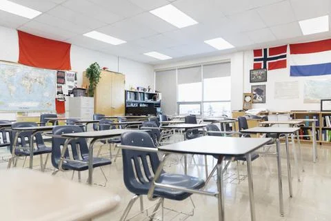 Desks and international flags in empty high school classroom Stock Photos