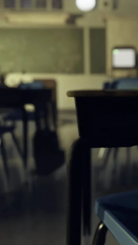 Desks in an empty classroom with a chalkboard and computer in the background Stock Footage 332227805